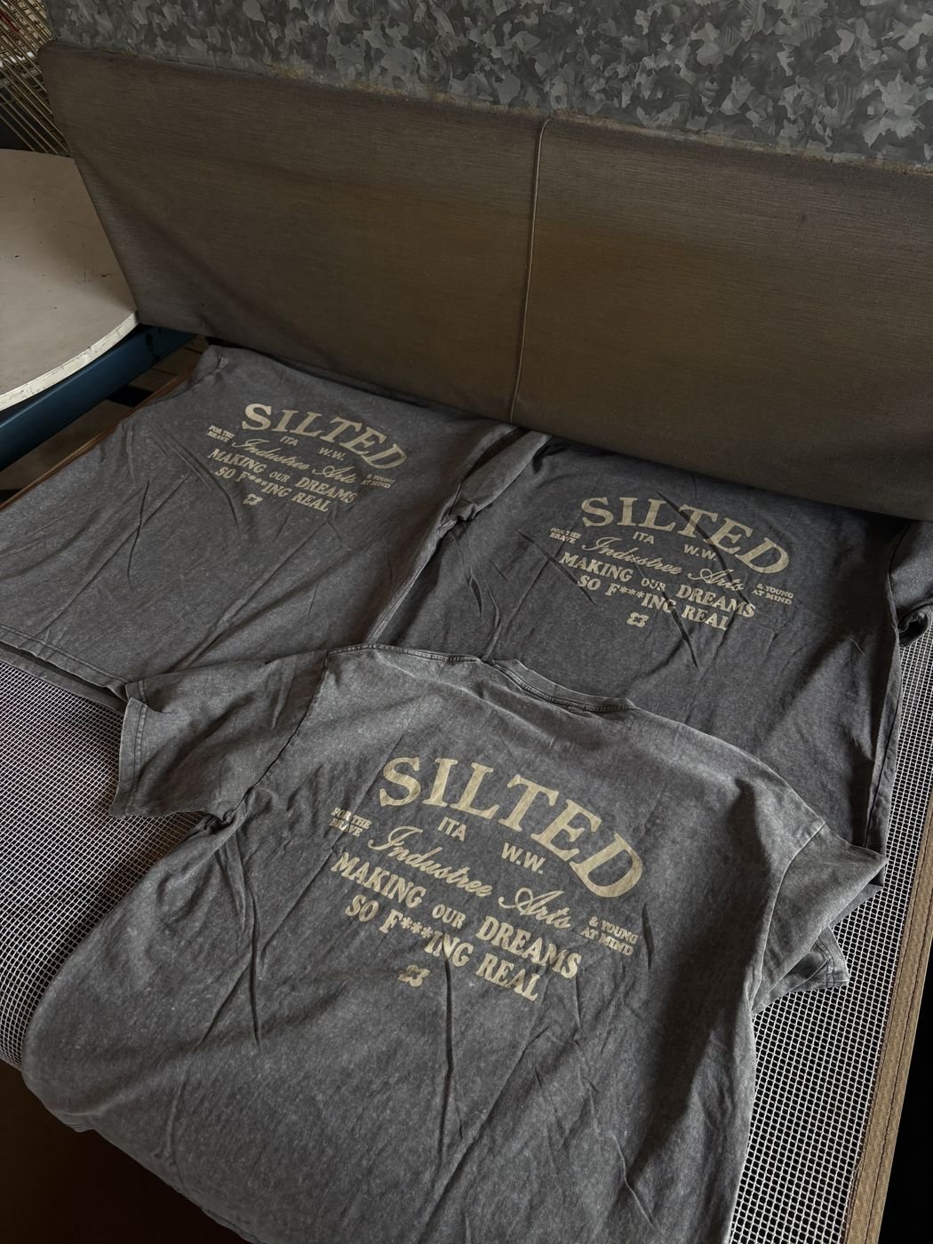 T-shirt grigie stampate in serigrafia sul piano di asciugatura